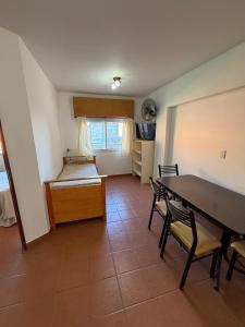 a room with a bed and a table and chairs at Departamentos Li-Del in Monte Hermoso