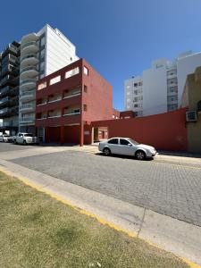 a car parked in front of a red brick building at Departamentos Li-Del in Monte Hermoso
