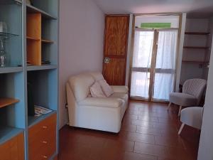 a living room with a white chair and a window at Uliveto in Sulzano +11 photos