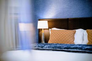 a bedroom with a bed with a blue wall at Gilmer Apartment Hotel in Wellington