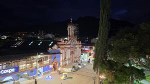 a building with a clock tower in a city at night at Hotel Vilcabamba Eterna Juventud in Vilcabamba