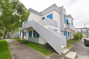 a white building with a staircase on the side of it at Beach House Quiaios in Figueira da Foz +2 photos