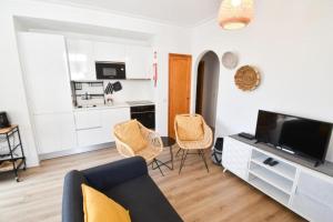 a living room with a couch and chairs and a kitchen at Beach House Quiaios in Figueira da Foz
