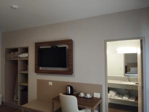 a hotel room with a desk and a television on the wall at DM Hoteles Ayacucho in Ayacucho