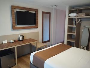 a bedroom with a bed and a desk and a television at DM Hoteles Ayacucho in Ayacucho