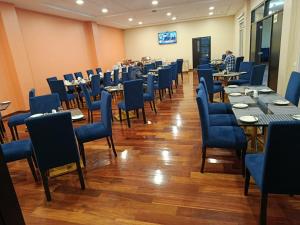 a dining room with tables and blue chairs at DM Hoteles Ayacucho in Ayacucho