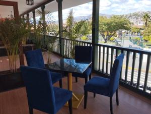 a balcony with blue chairs and a table and a view at DM Hoteles Ayacucho in Ayacucho