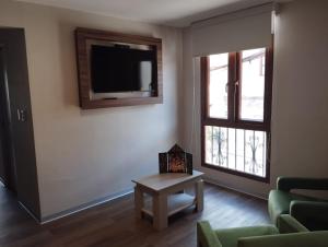 a living room with a tv and a couch and a table at DM Hoteles Ayacucho in Ayacucho +8 photos