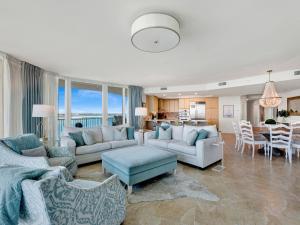 a living room with couches and a table and a kitchen at Caribe The Resort #C702 in Perdido Key