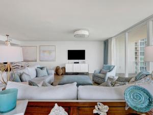 a living room with white furniture and a flat screen tv at Caribe The Resort #C702 in Perdido Key