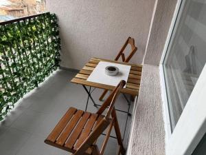 a small table and a chair on a balcony at Apartmani Preradović in Pančevo