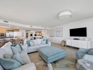 a living room with white furniture and a flat screen tv at Caribe The Resort #C702 in Perdido Key