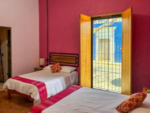 a room with two beds and a window at Suites Patio Antequera in Oaxaca City