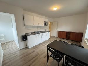 a kitchen with a table and chairs in a room at Pension Linderhof Augsburg in Augsburg +16 photos
