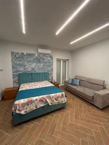 a bedroom with a bed and a couch at Domus Anna in Bacoli