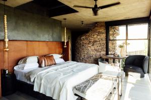 a bedroom with a large bed and a brick wall at Cypiro Leopard Lodge in Kransberg +65 photos