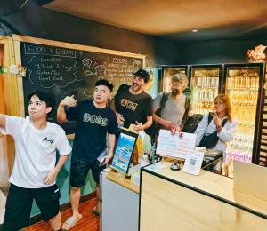 a group of people standing at a counter in a store at Guilin Cyan Box Guest House in Guilin