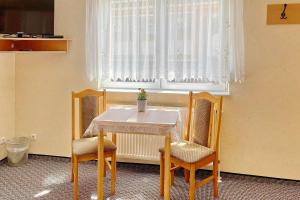 a table and chairs in a room with a window at Hibiskus in Lübbenau