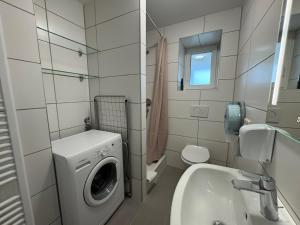a bathroom with a washing machine and a sink at Pension Linderhof Augsburg in Augsburg