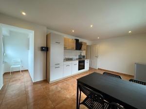 a kitchen and dining room with a table and chairs at Pension Linderhof Augsburg in Augsburg