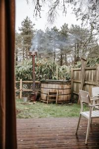 a patio with a table and chairs and a fence at Sky Cabin. Cosy Forest Log Cabin 3 night minimum in Wareham +7 photos