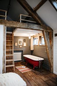 a bathroom with a red bath tub and a ladder at Sky Cabin. Cosy Forest Log Cabin 3 night minimum in Wareham