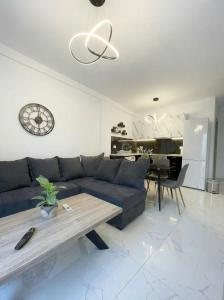 a living room with a blue couch and a table at White Port Suite in Ágios Rókkos