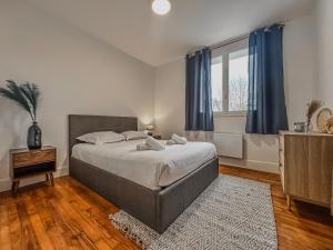 a bedroom with a large bed with blue curtains at Le Michels - Gare - CEA - STMicro in Fontaine
