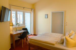 a bedroom with a bed and a desk with a computer at Hotel-Pension Lender in Bad Freienwalde