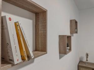 a row of books on a shelf on a wall at Le Michels - Gare - CEA - STMicro in Fontaine +45 photos