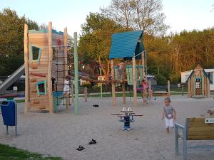 a young child standing in front of a playground at Chalet op Camping Mounewetter in Witmarsum