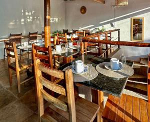 a restaurant with tables and chairs in a room at Pousada Zoom Jericoacoara in Jericoacoara
