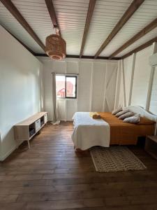 a bedroom with a large bed and a wooden floor at Bungalow cocon des alizés in Les Abymes