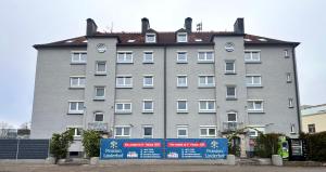 a large gray building with a sign in front of it at Pension Linderhof Augsburg in Augsburg