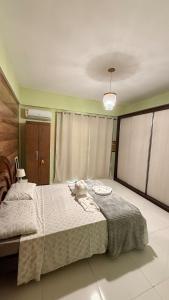 a bedroom with a large bed with a white blanket at Casa vista infinita in Mangaratiba