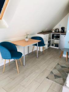a kitchen with a table and two blue chairs at Chambre d'hôtes La Bourdonnaise in Bourdonné +9 photos