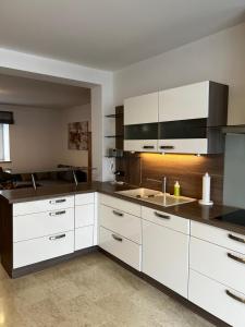 a kitchen with white cabinets and a sink at Ferienwohnung Rössler in Brannenburg