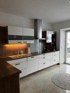 a kitchen with white cabinets and a sink at Ferienwohnung Rössler in Brannenburg