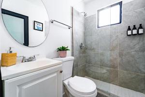 a bathroom with a toilet and a sink and a mirror at Tropical Getaway in Aguadilla +58 photos