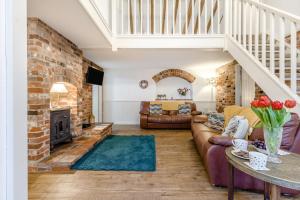 a living room with a couch and a fireplace at 3 Bed in Stratton Strawless oc-w34832 in Stratton Strawless