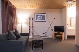 a living room with a couch and skis on the wall at EasyStay Inn & Suites Fernie in Fernie
