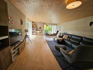a living room with a couch and a television at Modern, spacious villa with Sauna in Ruds-Vedby