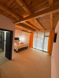 a bedroom with a bed and a large window at Zen Resort and Winery in Slănic +37 photos