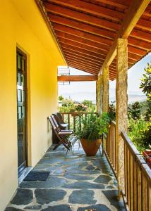 a porch with chairs and a wooden pergola at Barbeito Country House in Paraíso