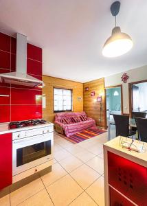 a kitchen with red cabinets and a living room at Barbeito Country House in Paraíso