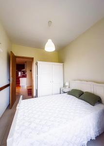 a bedroom with a large white bed in a room at Barbeito Country House in Paraíso