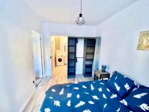 a bedroom with a blue bed with a blue comforter at Charmant 3 pièces in Saint-Claude +3 photos