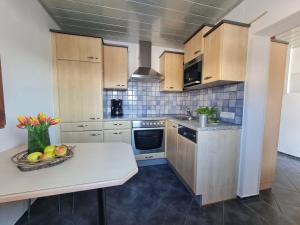 a kitchen with wooden cabinets and a bowl of fruit on a counter at Panorama Hof Sereinig in Sankt Oswald