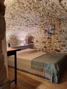 a bedroom with a bed in a stone wall at La chambre secrète in Aiguèze