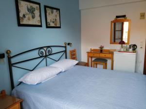 a bedroom with a bed with a white bedspread at Villa Mary Galini in Ireon